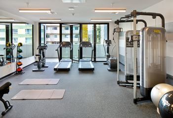 a fitness room with treadmills and other exercise equipment
